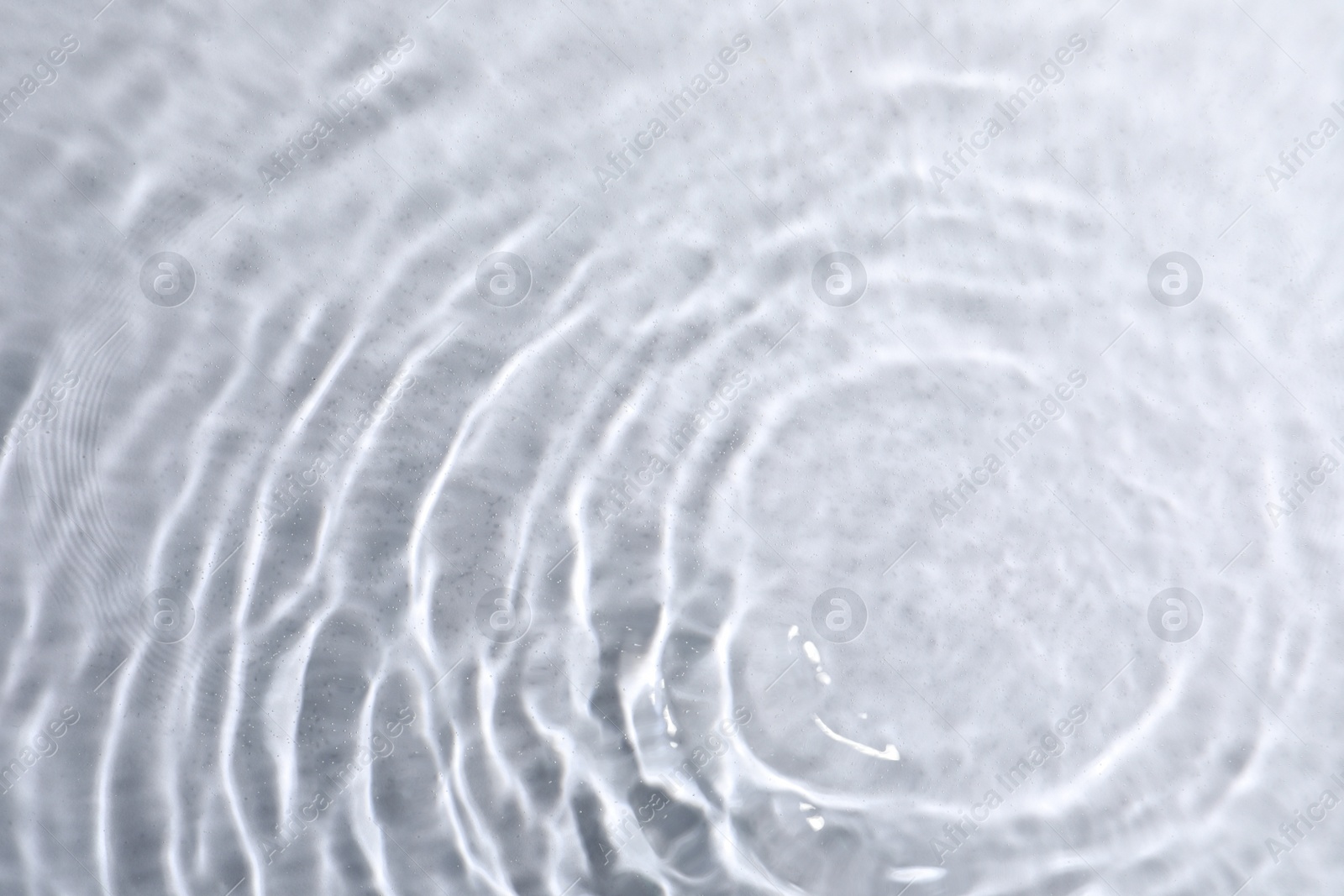 Photo of Closeup view of water with rippled surface on light background