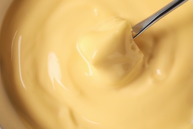 Photo of Dipping bread into tasty cheese fondue, top view