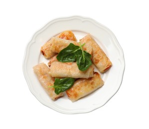 Tasty fried spring rolls and spinach isolated on white, top view