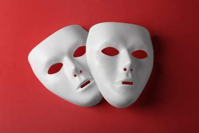 Photo of White theatre masks on red background, flat lay