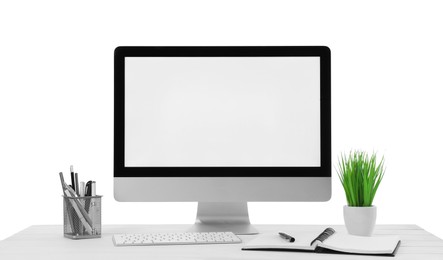 Computer, potted plant and stationery on table against white background. Stylish workplace