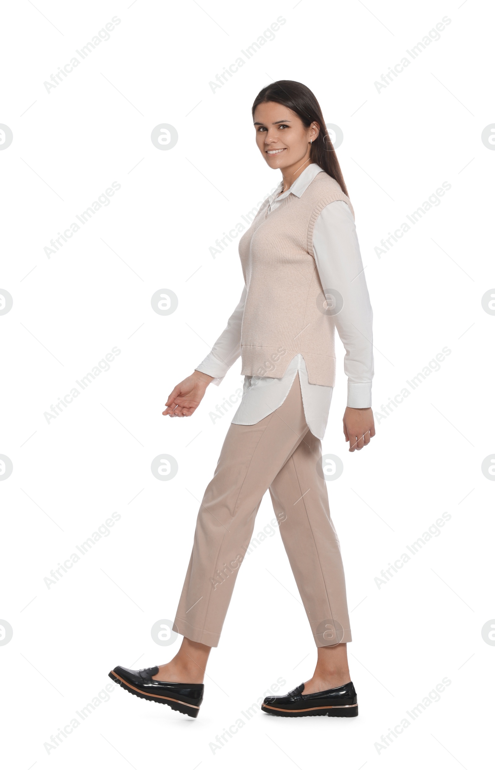 Photo of Young woman in stylish outfit walking on white background