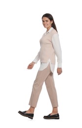 Photo of Young woman in stylish outfit walking on white background