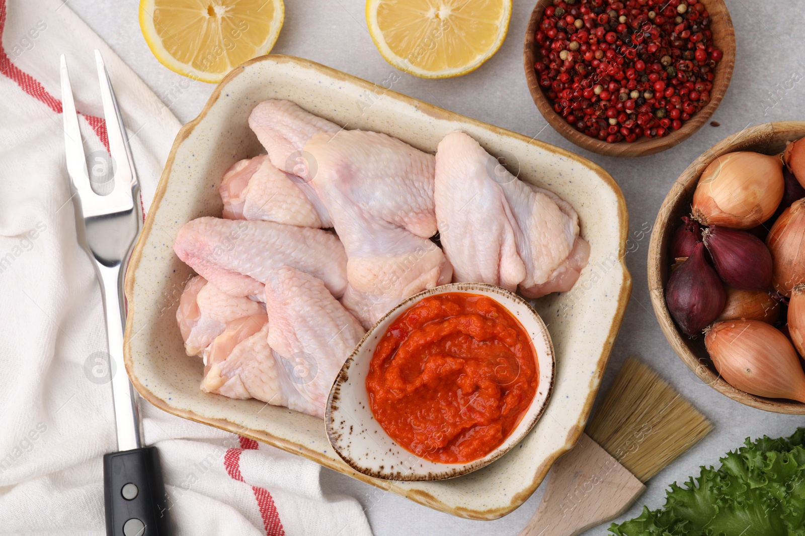 Photo of Flat lay composition with marinade, raw chicken and other products on light table