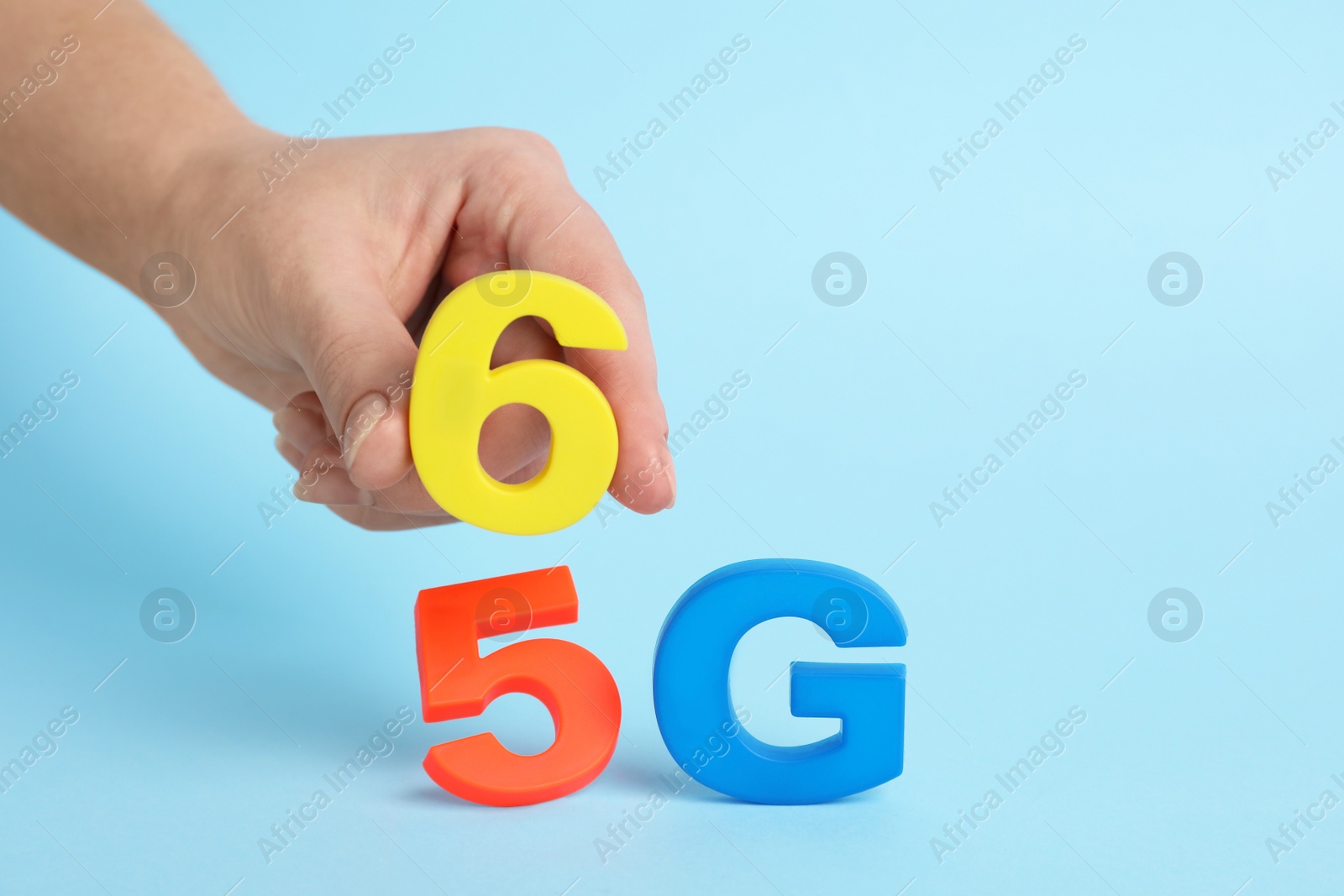 Photo of Man putting 6G instead 5G on light blue background, closeup