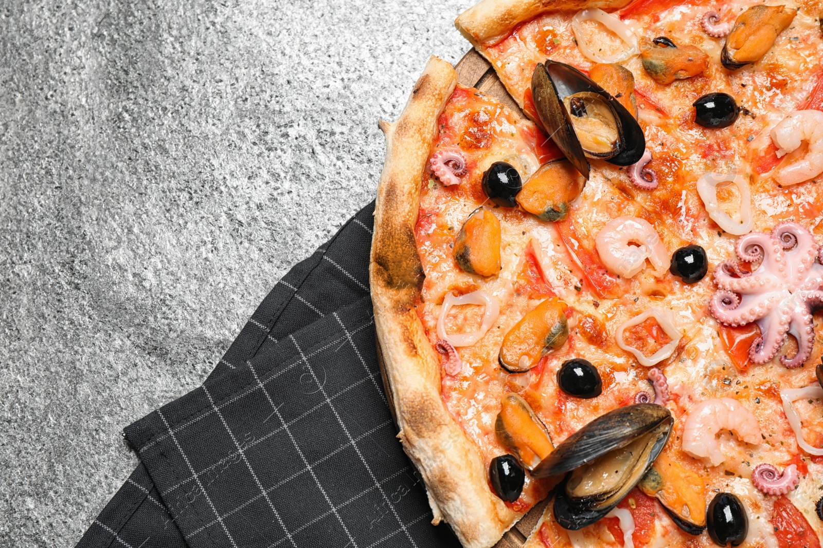 Photo of Tasty pizza with seafood on grey table, top view