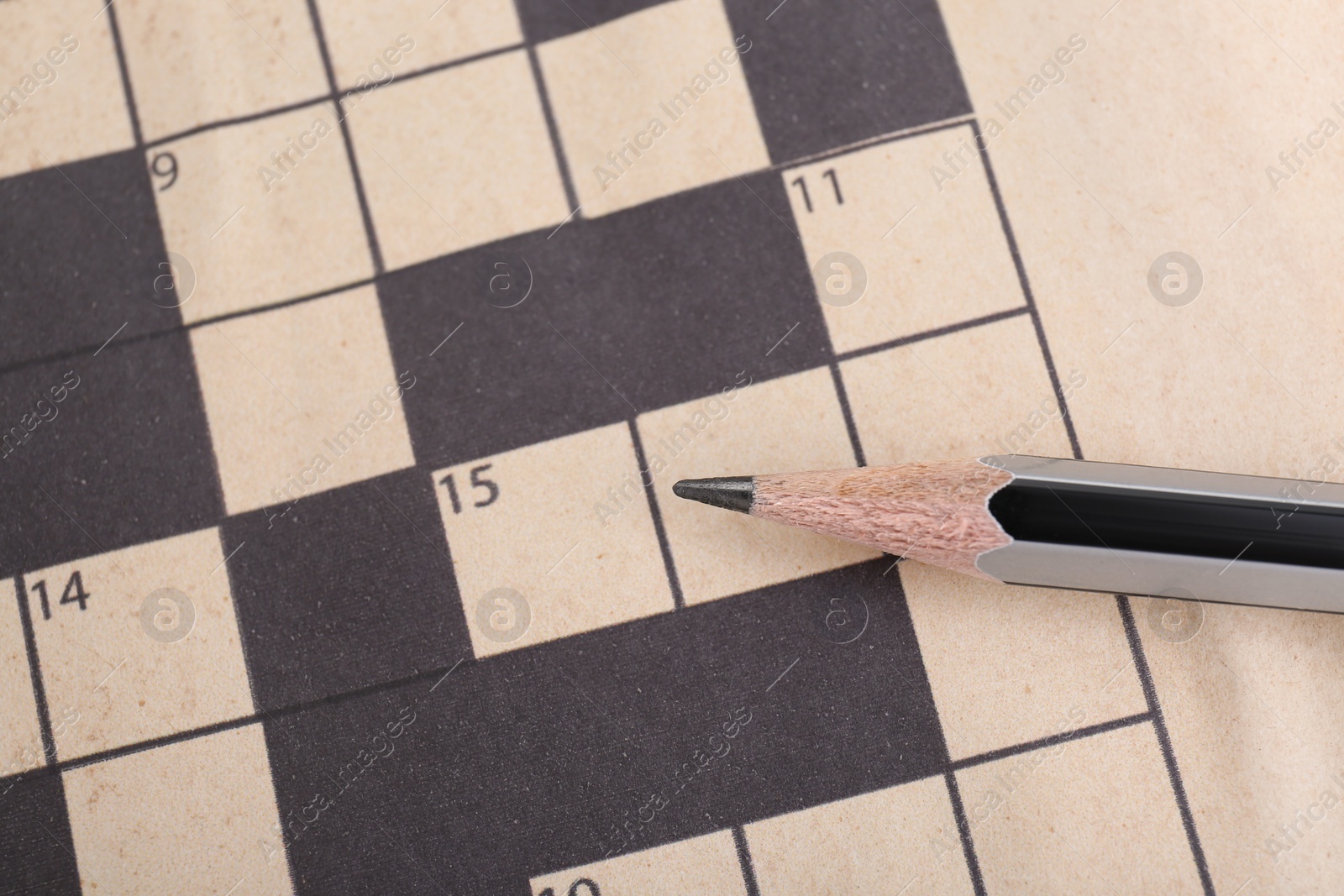 Photo of Pencil on blank crossword, top view. Space for text