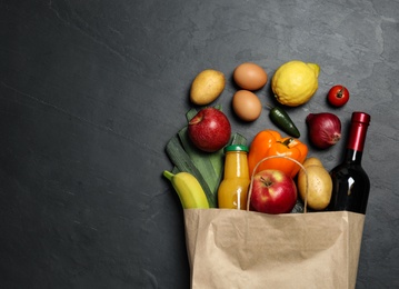 Photo of Paper bag with groceries on grey background, flat lay