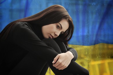 Upset woman and national flag on background. Stop war in Ukraine