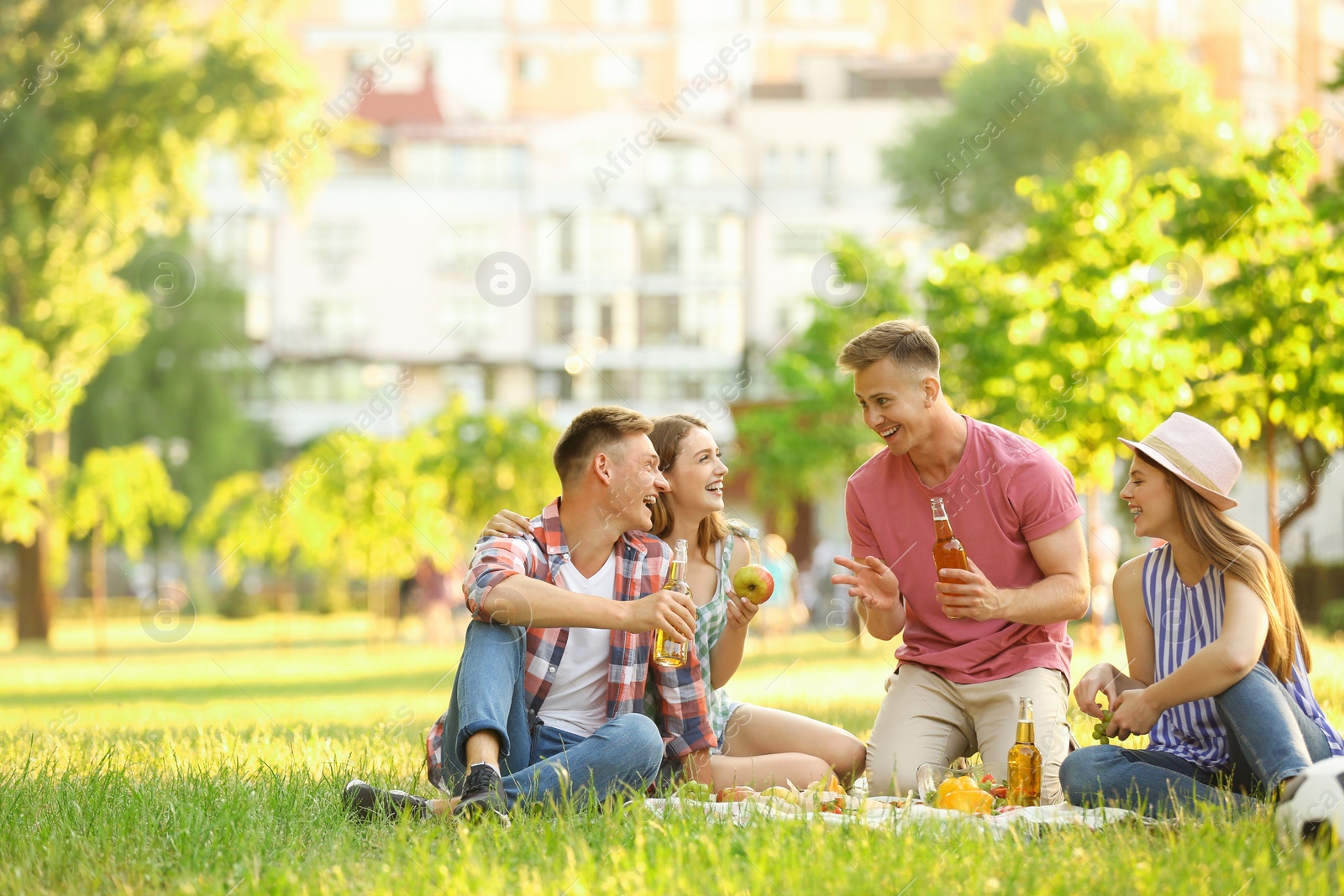 Photo of Young people enjoying picnic in park on summer day