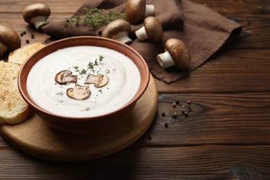 Photo of Fresh homemade mushroom soup in ceramic bowl on wooden table