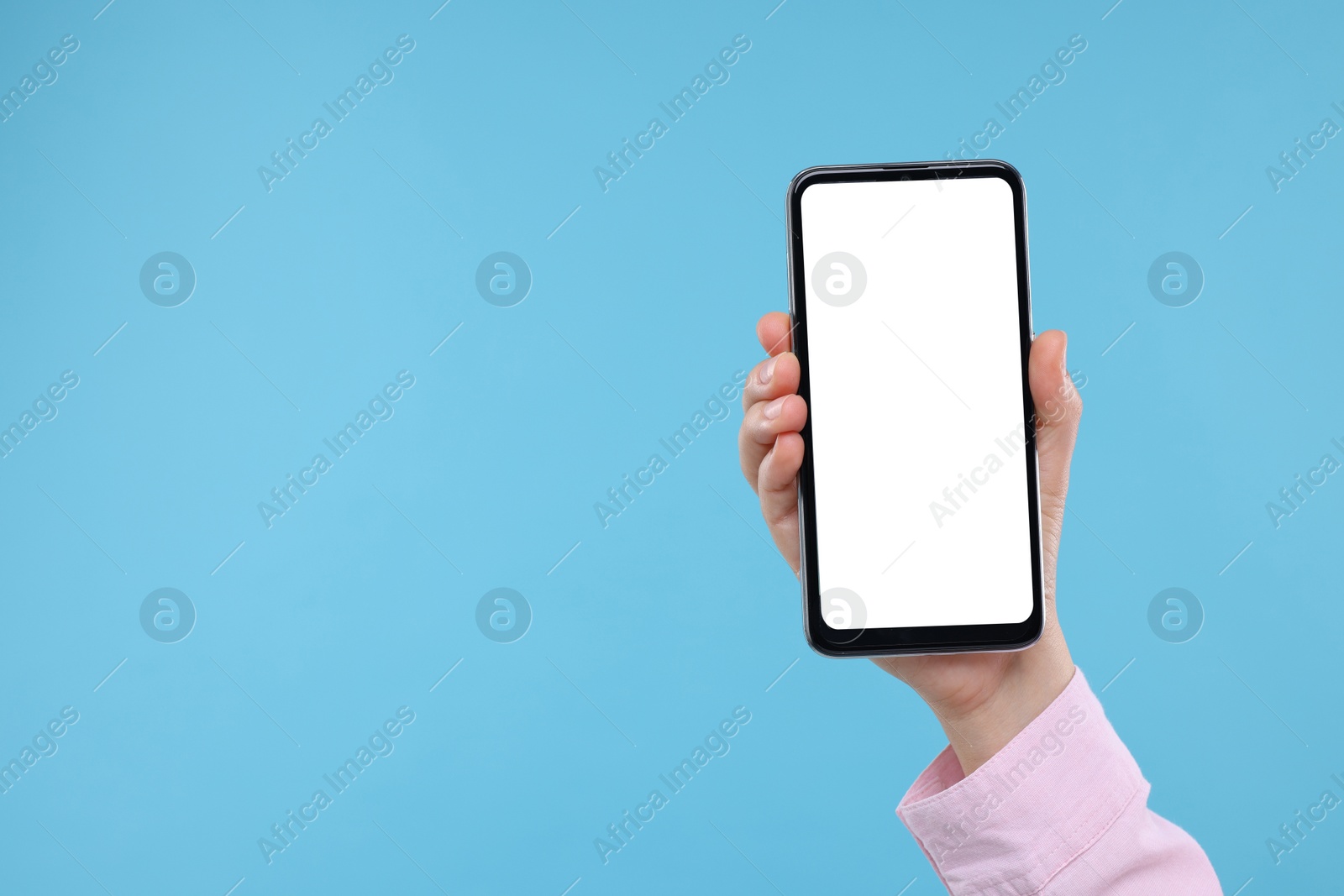 Photo of Woman holding smartphone with blank screen on light background, closeup. Mockup for design