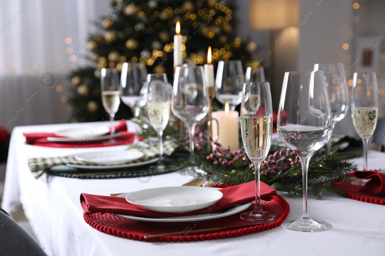 Photo of Christmas table setting with festive decor and dishware indoors