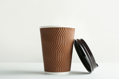 Photo of Takeaway paper coffee cup and lid on white background