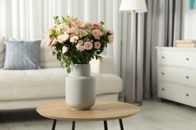 Photo of Beautiful bouquet of fresh flowers in vase on wooden coffee table indoors, space for text