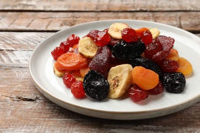 Mix of delicious dried fruits on wooden table, closeup