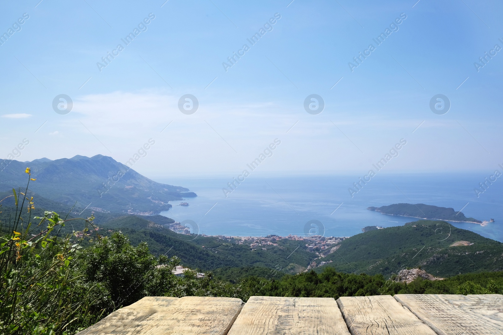 Image of Empty wooden surface and view of beautiful mountains and sea on sunny day