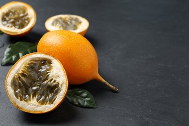 Photo of Delicious ripe granadillas on black table. Space for text