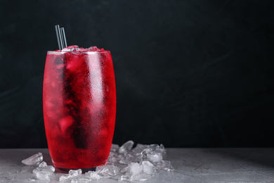 Photo of Bright cocktail with ice cubes on light grey table, closeup. Space for text