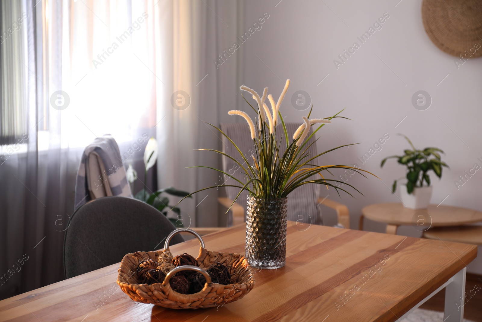 Photo of Vase on wooden table near window with curtains in room