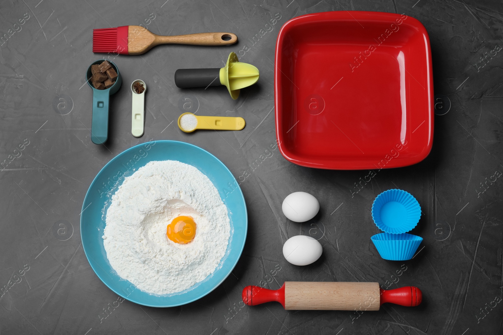 Photo of Cooking utensils and ingredients on black table, flat lay