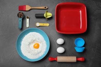 Cooking utensils and ingredients on black table, flat lay