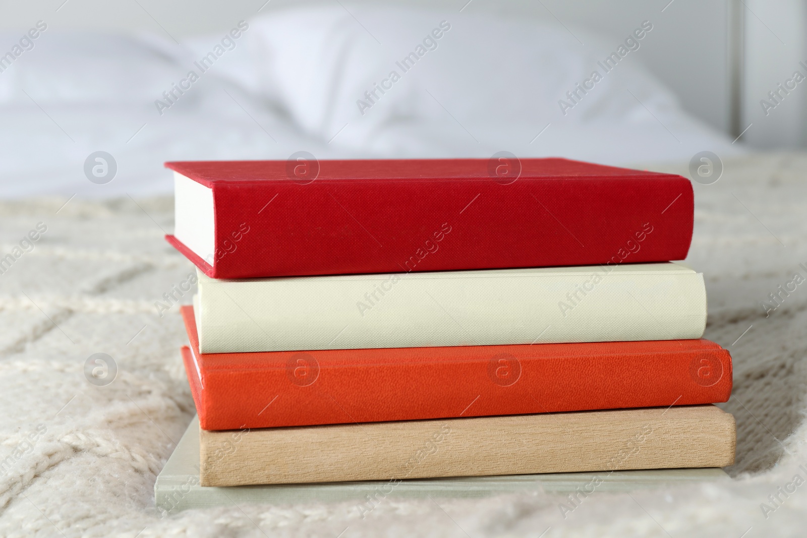 Photo of Books on white soft blanket in bedroom