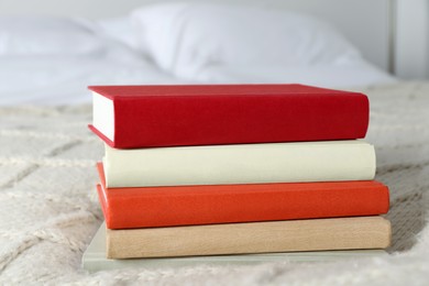 Photo of Books on white soft blanket in bedroom