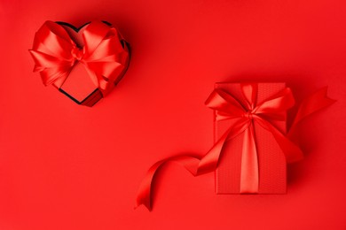 Photo of Beautiful gift boxes with bows on red background, flat lay