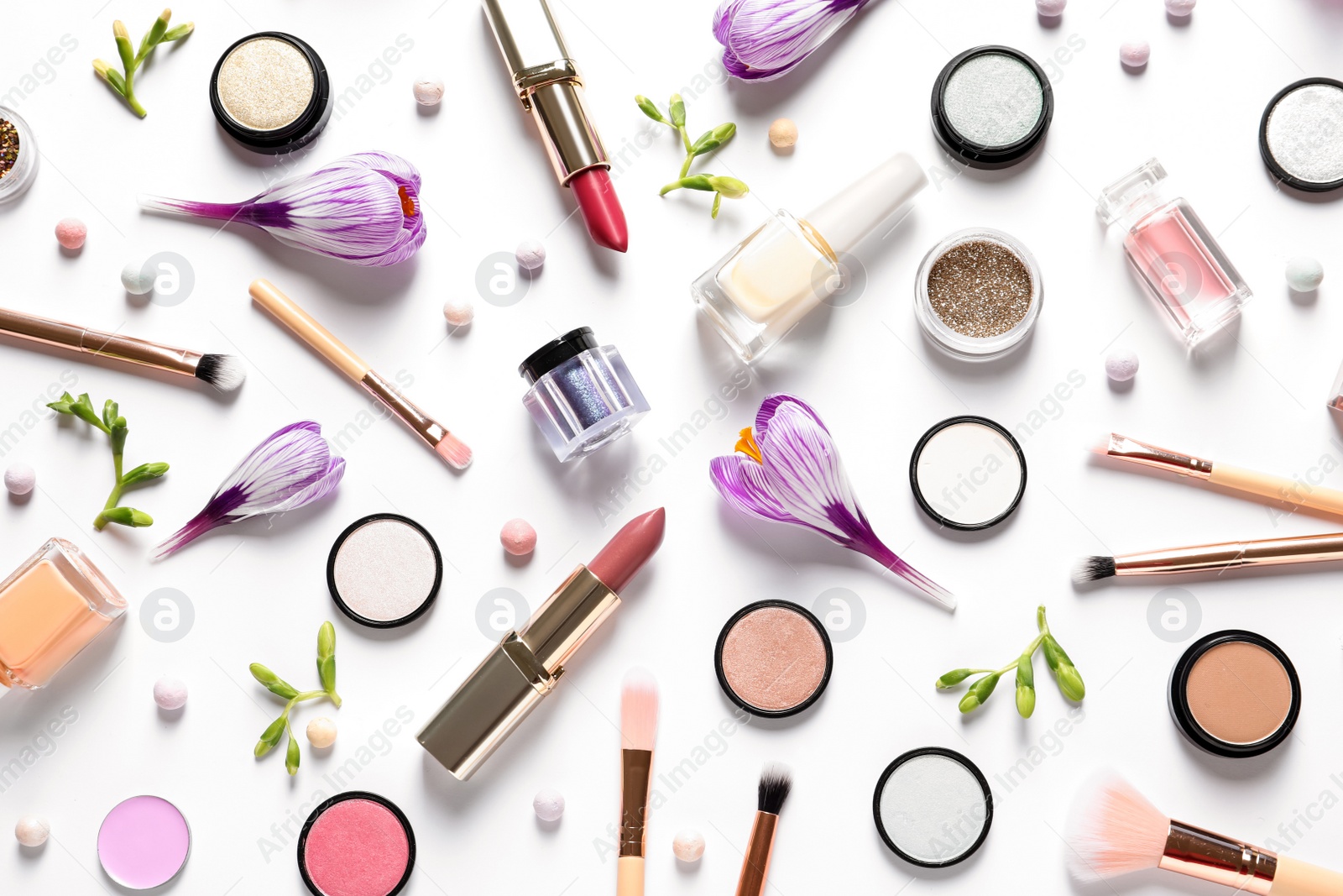 Photo of Different makeup products and flowers on white background, top view