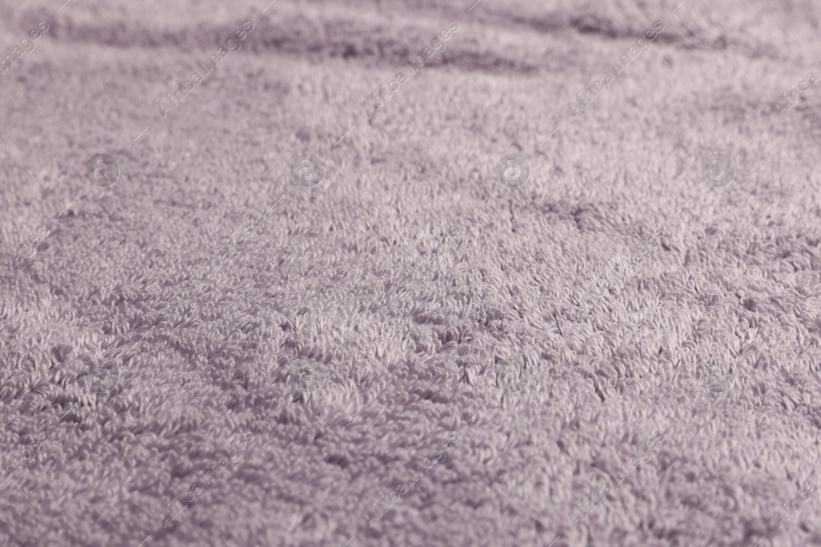 Photo of Dry soft pale purple towel as background, closeup