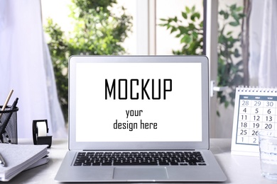 Modern laptop with text Mockup Your Design Here on screen