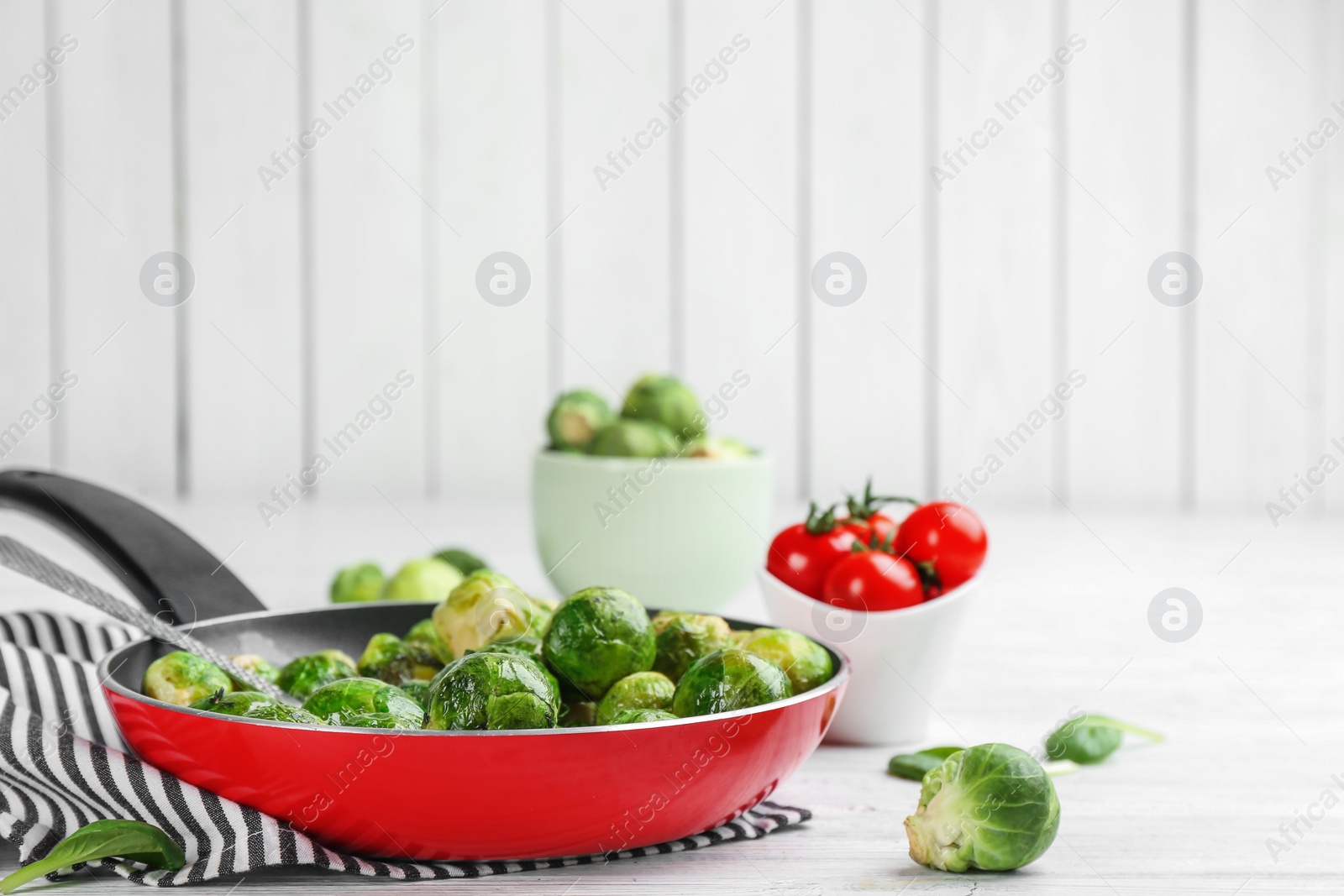 Photo of Roasted Brussels sprouts in pan on white wooden table