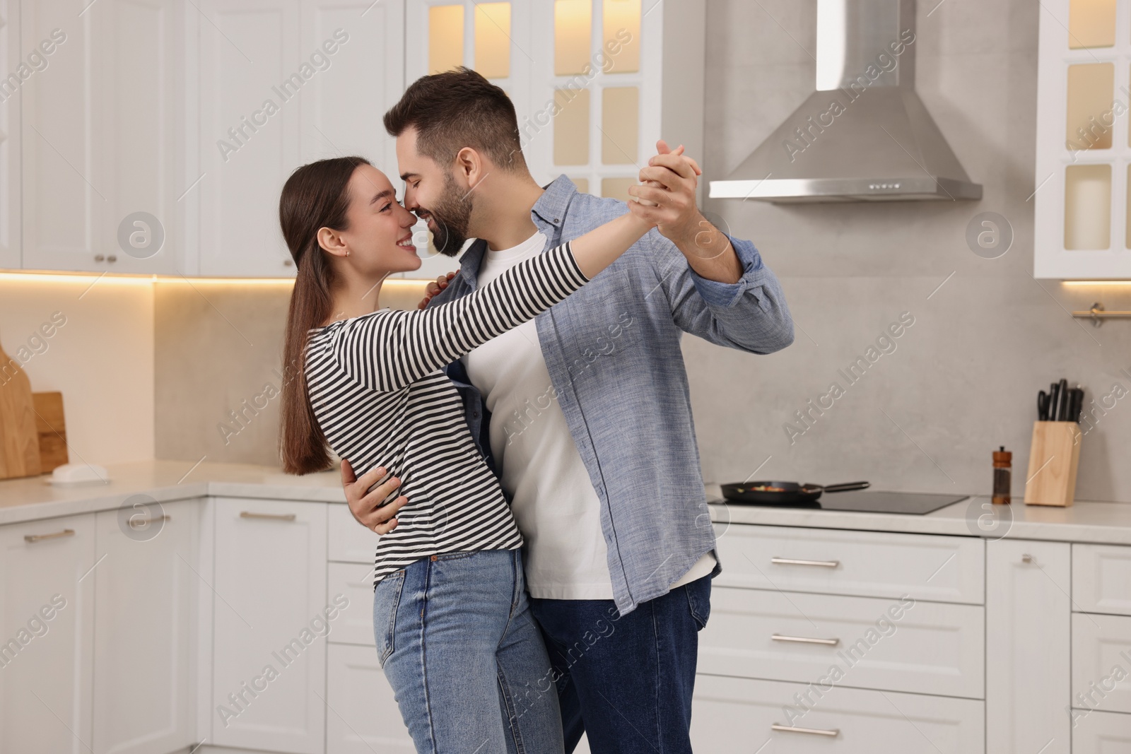 Photo of Happy lovely couple dancing together in kitchen