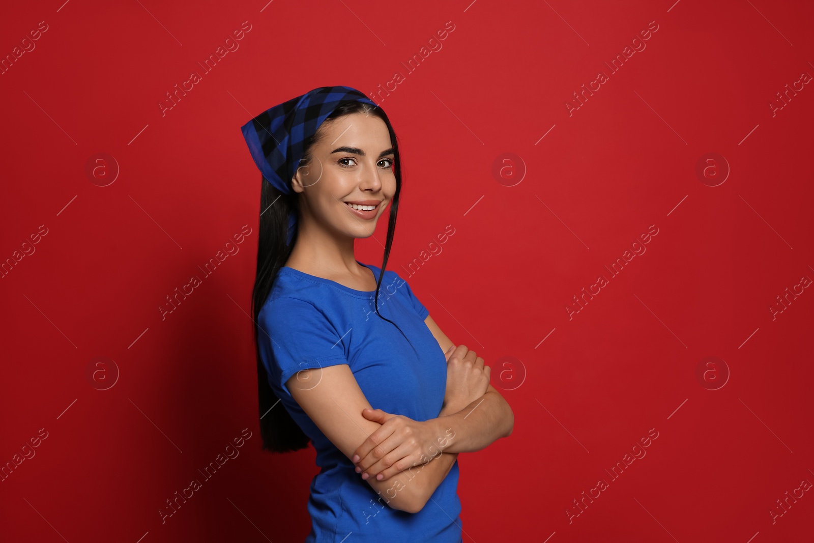 Photo of Young woman wearing stylish bandana on red background, space for text