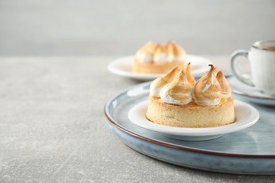Photo of Delicious lemon meringue pie on grey table, closeup. Space for text