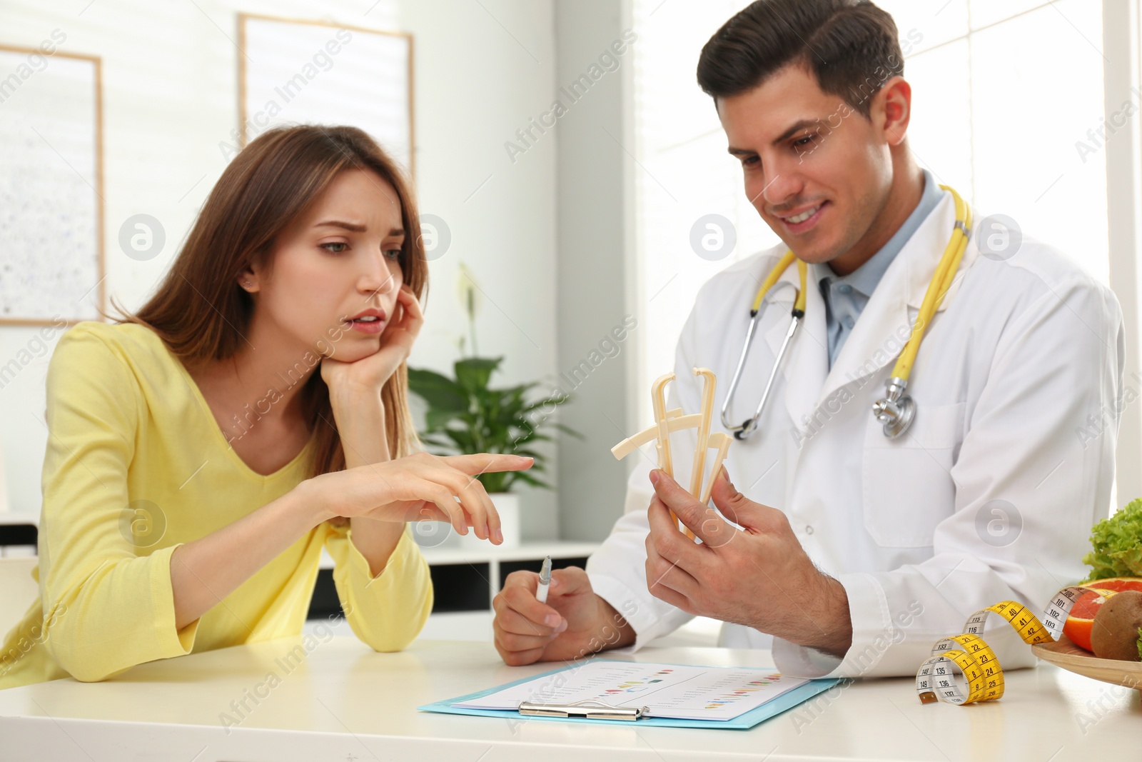 Photo of Nutritionist consulting patient at table in clinic