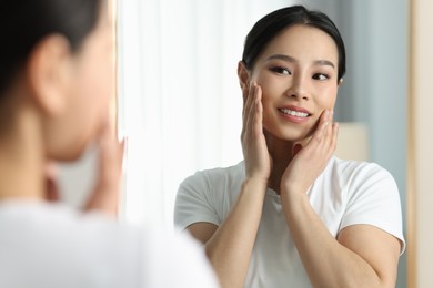 Photo of Portrait of beautiful woman near mirror indoors