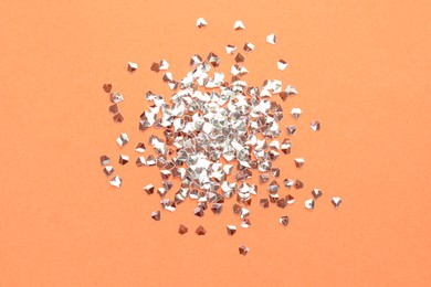 Pile of shiny glitter on pale pink background, flat lay