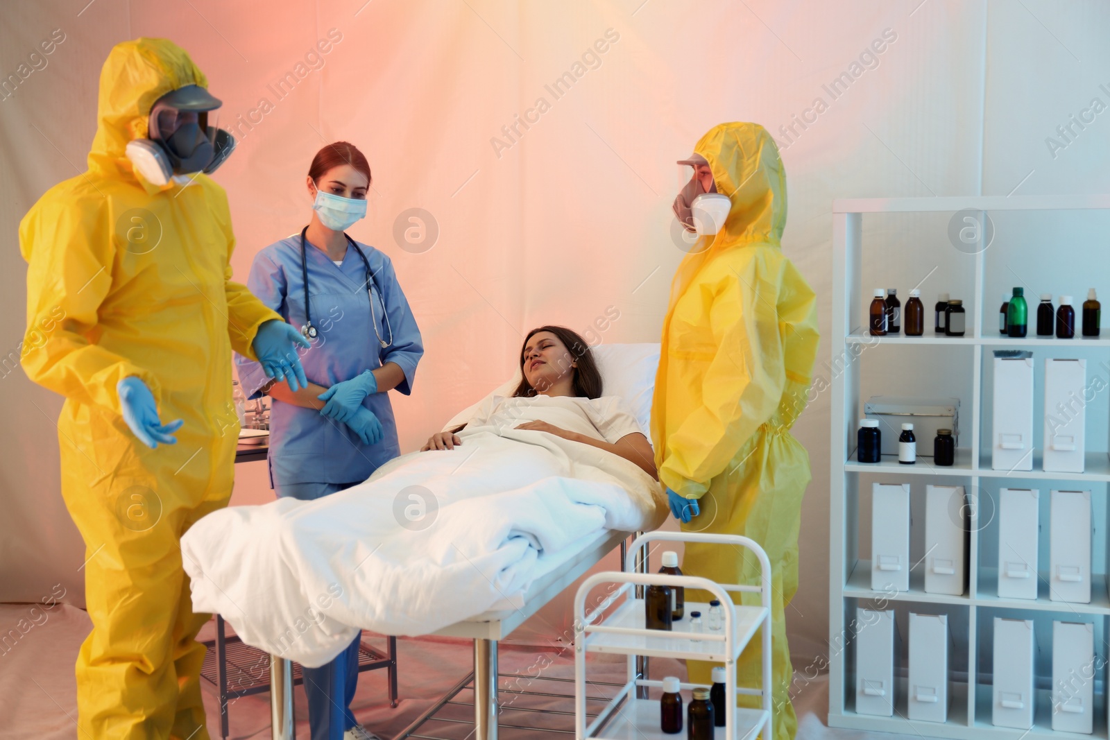 Photo of Professional paramedics examining patient with virus in quarantine ward