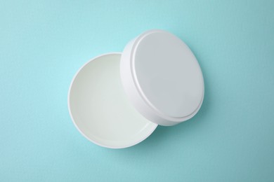 Jar of petroleum jelly on light blue background, top view