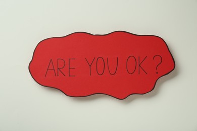 Photo of Red card with phrase Are You Ok? on beige background