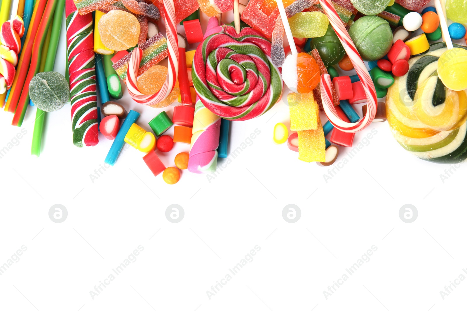 Photo of Many different yummy candies on white background, top view. Space for text