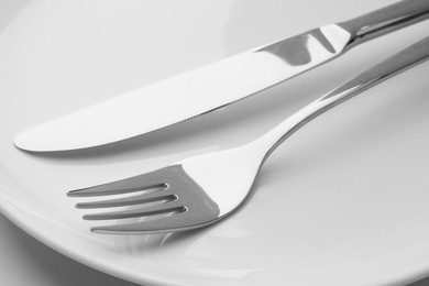 Photo of Clean plates, fork and knife, closeup view