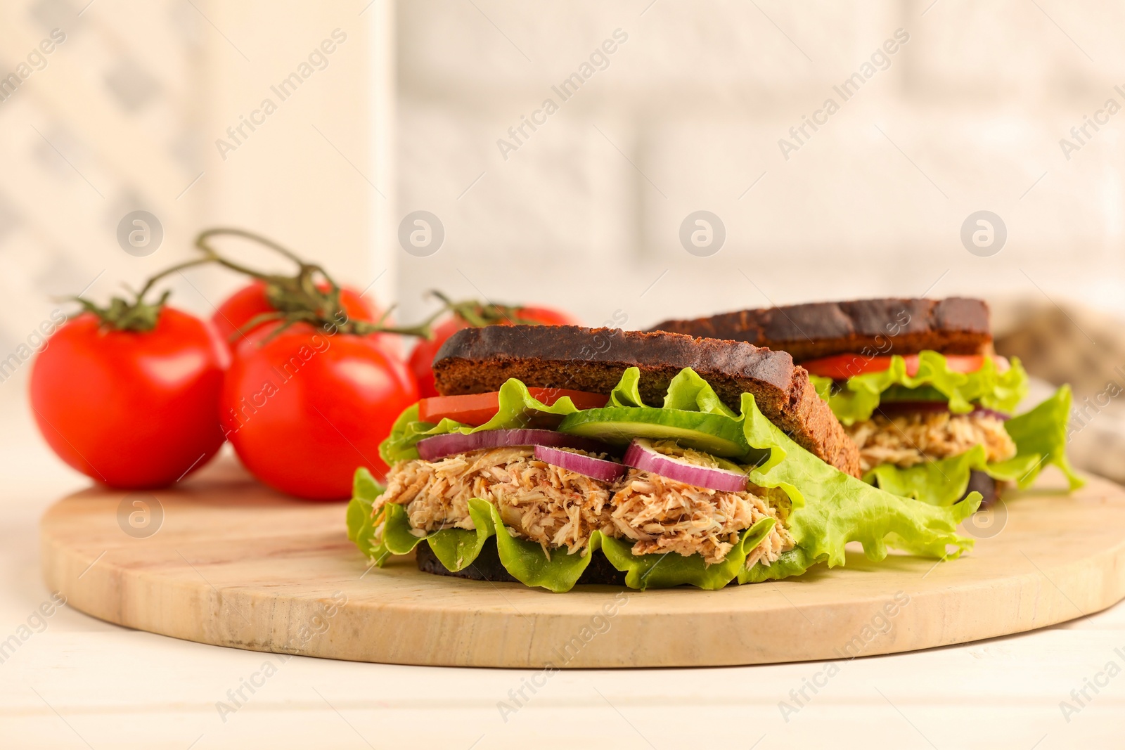 Photo of Delicious sandwiches with tuna and vegetables on white table