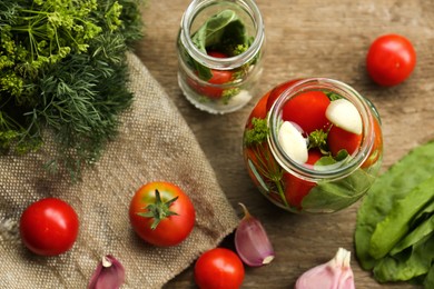 Photo of Glass jars, fresh vegetables and herbs on wooden table, flat lay. Pickling recipe
