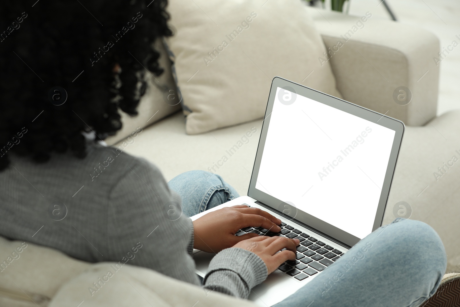 Photo of Woman using laptop on sofa indoors, closeup