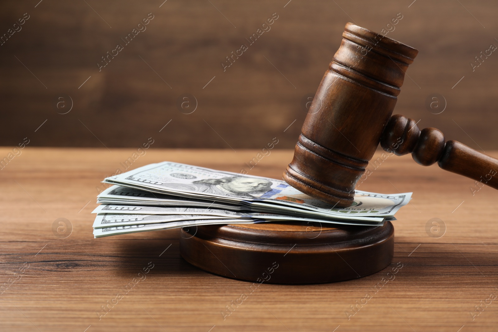 Photo of Judge's gavel and money on wooden table. Space for text