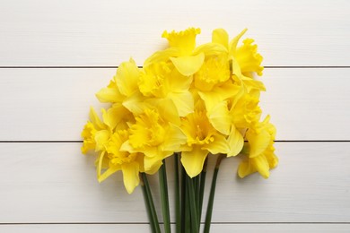 Photo of Beautiful daffodil bouquet on white wooden table, top view