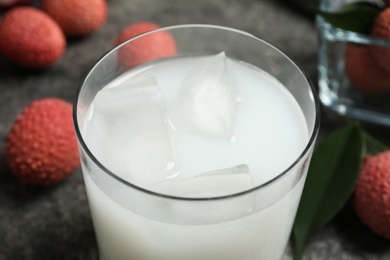 Photo of Fresh lychee juice on grey table, closeup